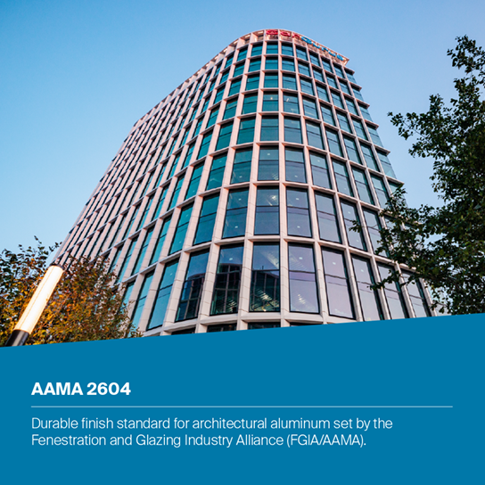 A modern curved office building with a glass curtain wall under a clear blue sky, with a blue text banner at the bottom reading 'AAMA 2604' and descriptive copy about architectural aluminum finish.